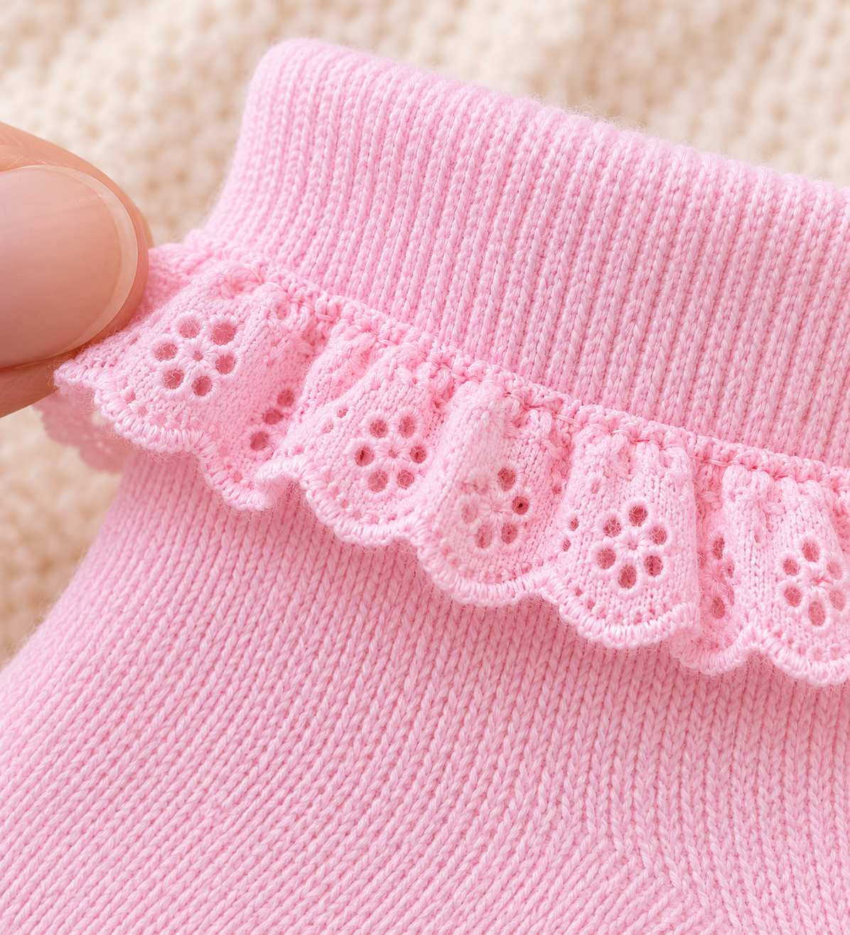 Macro view of pink eyelet lace edging and fine cotton sock knitting